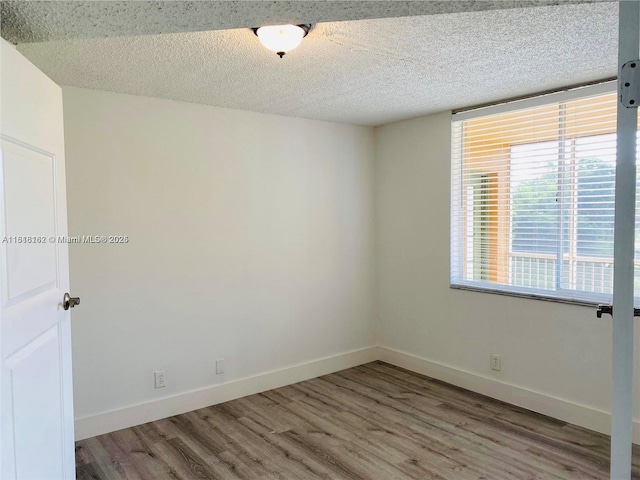 4015 W Mcnab Rd Unit D203, Pompano Beach, FL 33069 - unfurnished room featuring wood finished floors, a textured ceiling, and baseboards
