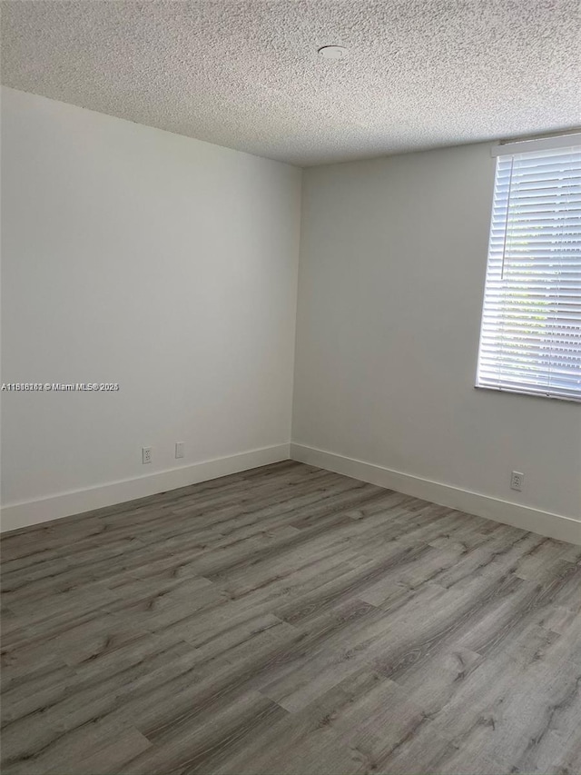 4015 W Mcnab Rd Unit D203, Pompano Beach, FL 33069 - spare room with a textured ceiling, wood finished floors, and baseboards