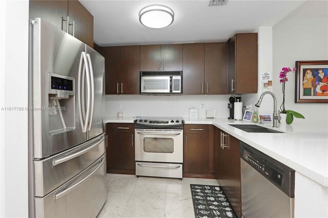 10 Aragon Ave Unit 919, Coral Gables, FL 33134 - kitchen with stainless steel appliances, light countertops, a sink, and dark brown cabinets