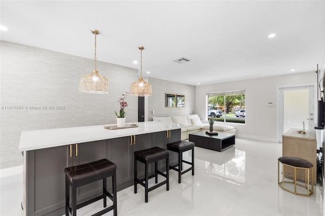 6301 Lake Geneva Rd, Miami Lakes, FL 33014 - kitchen with light countertops, a kitchen bar, recessed lighting, hanging light fixtures, and light tile patterned floors
