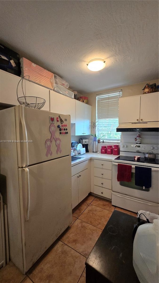 13655 NE 10th Ave Unit 108, North Miami, FL 33161 - kitchen with white appliances, white cabinetry, light tile patterned floors, a textured ceiling, and light countertops