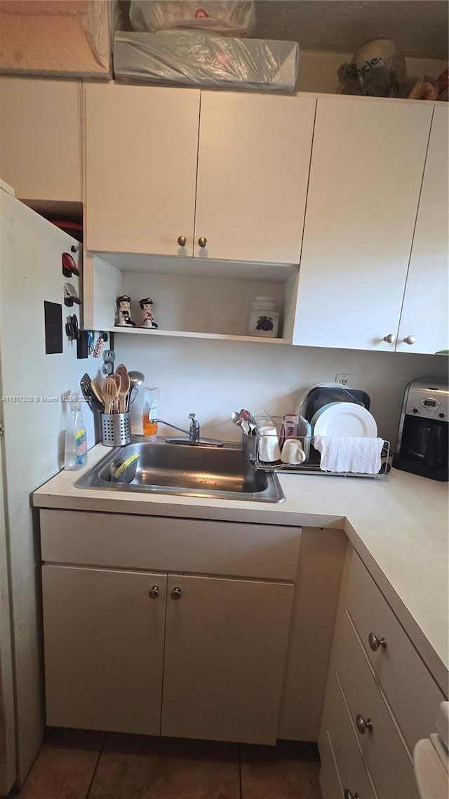 13655 NE 10th Ave Unit 108, North Miami, FL 33161 - kitchen with open shelves, a sink, light countertops, and dark tile patterned flooring