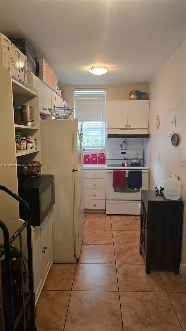 13655 NE 10th Ave Unit 108, North Miami, FL 33161 - kitchen with white appliances, white cabinetry, light tile patterned flooring, and under cabinet range hood