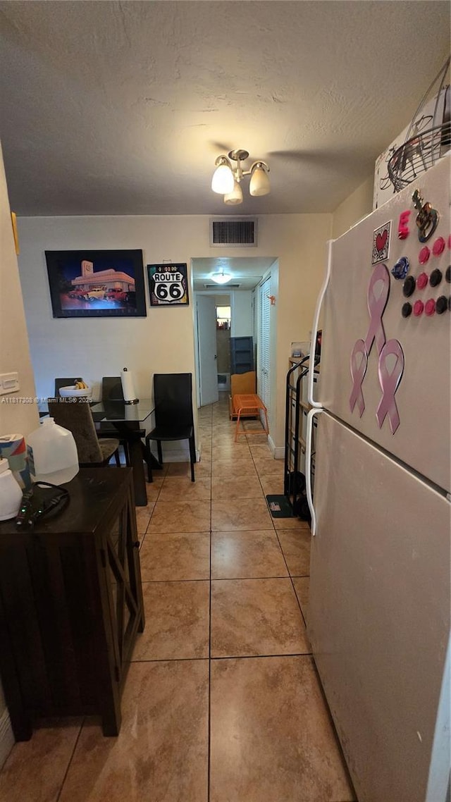 13655 NE 10th Ave Unit 108, North Miami, FL 33161 - hall with light tile patterned flooring, a textured ceiling, and baseboards