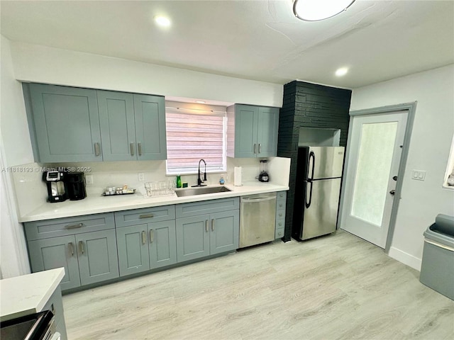 230 NE 2nd Pl, Dania Beach, FL 33004 - kitchen featuring stainless steel appliances, a sink, light wood-style flooring, light countertops, and baseboards