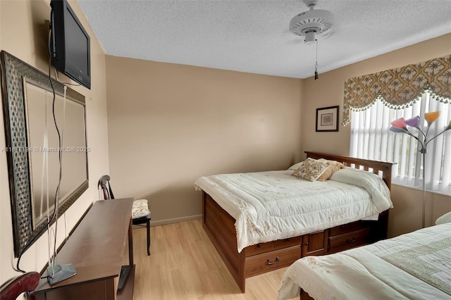 424 SE 10th St Unit 402, Dania Beach, FL 33004 - bedroom with light wood-style floors, a textured ceiling, and baseboards
