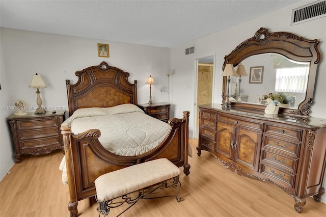 424 SE 10th St Unit 402, Dania Beach, FL 33004 - bedroom featuring light wood-style flooring, a textured ceiling, and ensuite bath