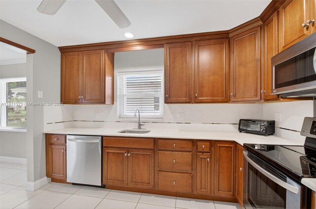 3810 Rowena Cir, West Palm Beach, FL 33417 - kitchen with appliances with stainless steel finishes, a sink, brown cabinetry, light countertops, and recessed lighting