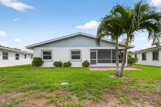 3810 Rowena Cir, West Palm Beach, FL 33417 - back of property with a yard, a sunroom, and stucco siding