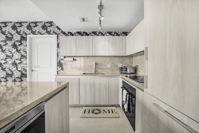 3131 NE 7th Ave Unit 3306, Miami, FL 33137 - kitchen featuring wallpapered walls, a sink, black appliances, light stone counters, and track lighting