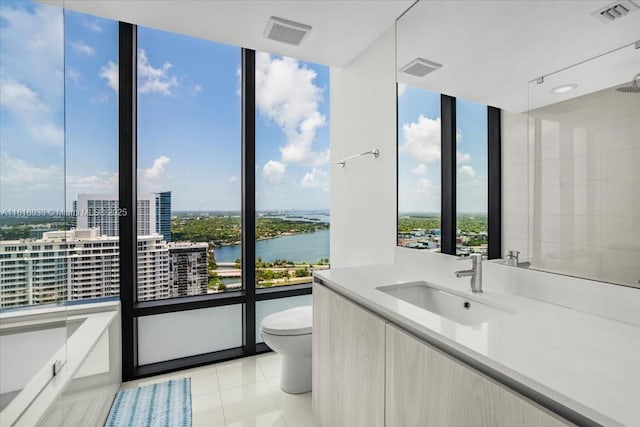 3131 NE 7th Ave Unit 3306, Miami, FL 33137 - bathroom with toilet, vanity, a water view, a wall of windows, and tile patterned floors