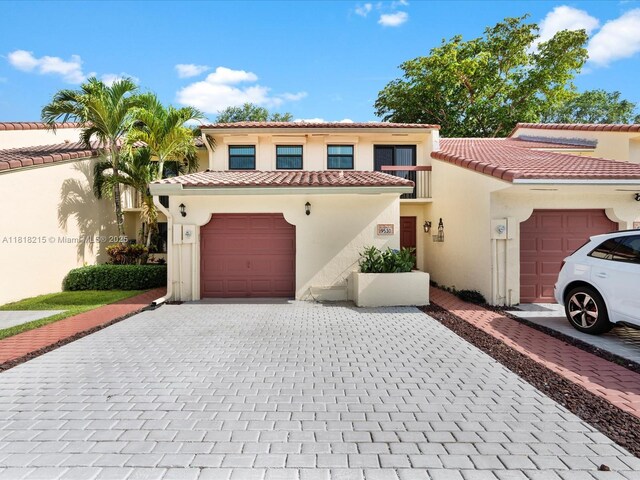 9530 Alcazar Ln, Davie, FL 33324 - mediterranean / spanish house featuring decorative driveway, stucco siding, a garage, and a tiled roof