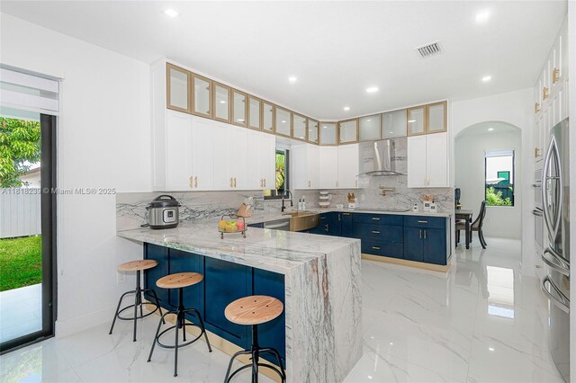 18250 SW 152nd Ave, Miami, FL 33187 - kitchen featuring wall chimney exhaust hood, tasteful backsplash, blue cabinetry, light marble finish flooring, and recessed lighting