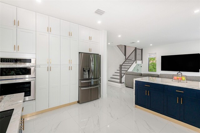 18250 SW 152nd Ave, Miami, FL 33187 - kitchen with stainless steel appliances, blue cabinets, white cabinetry, open floor plan, and recessed lighting