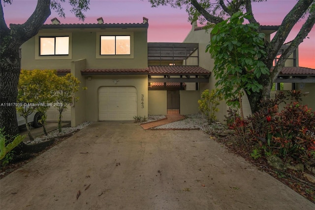 3643 Estepona Ave Unit B28-A, Doral, FL 33178 - view of front facade with a tile roof, an attached garage, stucco siding, and driveway