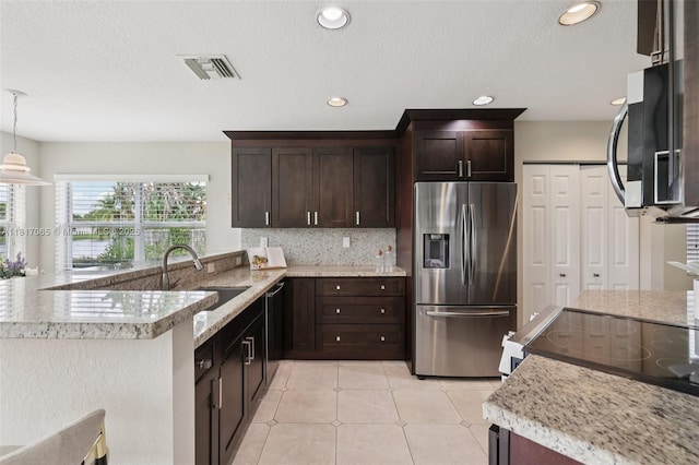 16710 NW 12th St, Pembroke Pines, FL 33028 - kitchen with appliances with stainless steel finishes, dark brown cabinets, decorative backsplash, a peninsula, and hanging light fixtures