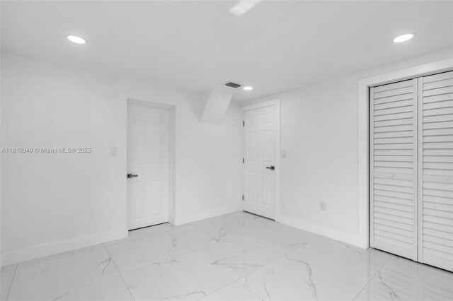 1010 NE 140th St, North Miami, FL 33161 - unfurnished bedroom featuring baseboards, recessed lighting, light marble finish flooring, and a closet