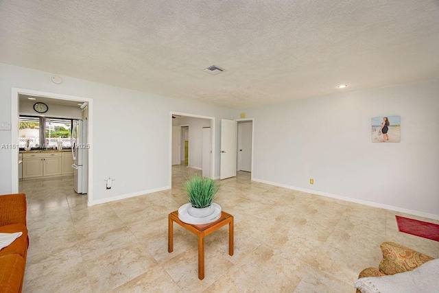 1801 N 55th Ave, Hollywood, FL 33021 - unfurnished living room with a textured ceiling, baseboards, and light tile patterned flooring