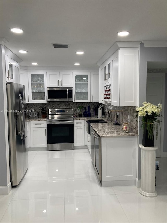 3364 NW 47th Ave Unit 3266, Coconut Creek, FL 33063 - kitchen with appliances with stainless steel finishes, light stone countertops, backsplash, white cabinets, and recessed lighting