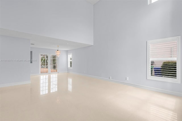 2256 SW 183rd Ter, Miramar, FL 33029 - spare room with a chandelier, a towering ceiling, and baseboards