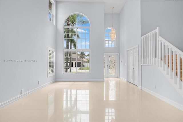 2256 SW 183rd Ter, Miramar, FL 33029 - entryway featuring a towering ceiling, baseboards, stairs, and tile patterned flooring
