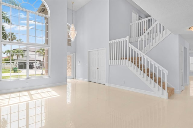 2256 SW 183rd Ter, Miramar, FL 33029 - entrance foyer with tile patterned flooring, stairs, a towering ceiling, and baseboards