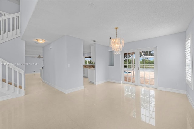2256 SW 183rd Ter, Miramar, FL 33029 - tiled spare room featuring healthy amount of natural light, stairs, a chandelier, ceiling fan, and a textured ceiling