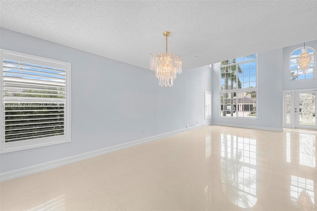 2256 SW 183rd Ter, Miramar, FL 33029 - tiled spare room featuring a chandelier, a textured ceiling, and baseboards