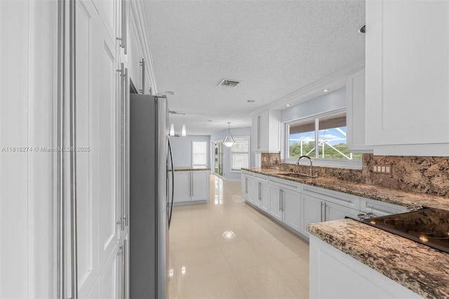 2256 SW 183rd Ter, Miramar, FL 33029 - kitchen featuring freestanding refrigerator, a sink, white cabinets, a textured ceiling, and backsplash