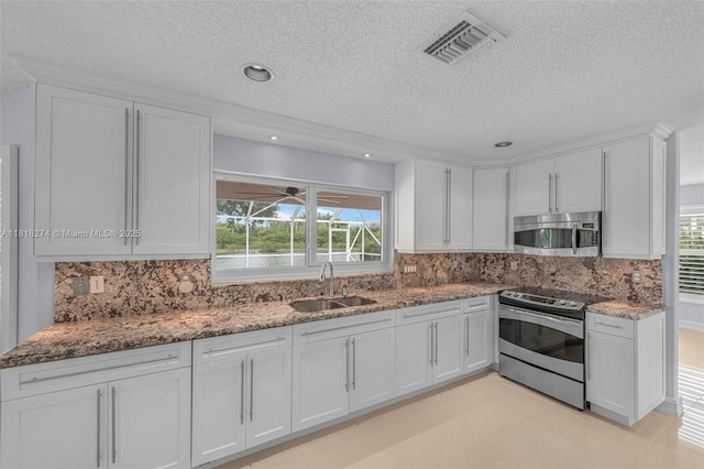 2256 SW 183rd Ter, Miramar, FL 33029 - kitchen featuring a sink, appliances with stainless steel finishes, a textured ceiling, white cabinets, and light stone counters
