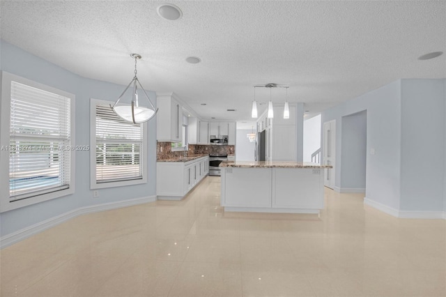 2256 SW 183rd Ter, Miramar, FL 33029 - kitchen featuring stainless steel appliances, decorative backsplash, white cabinets, baseboards, and a textured ceiling