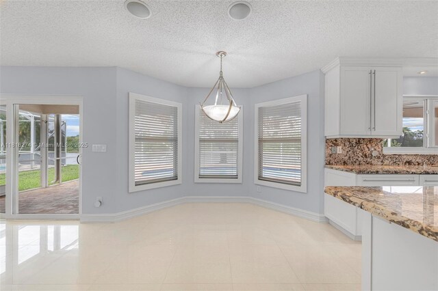 2256 SW 183rd Ter, Miramar, FL 33029 - unfurnished dining area featuring a textured ceiling, light tile patterned flooring, and baseboards