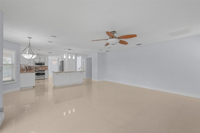 2256 SW 183rd Ter, Miramar, FL 33029 - unfurnished living room with a ceiling fan, a textured ceiling, and baseboards