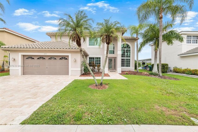2256 SW 183rd Ter, Miramar, FL 33029 - mediterranean / spanish home featuring decorative driveway, a garage, a front lawn, stucco siding, and a tile roof