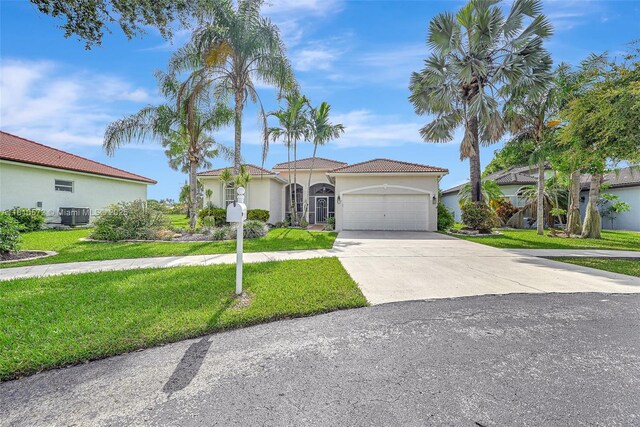 2775 Dunwoodie Pl, Homestead, FL 33035 - mediterranean / spanish-style home with a garage, a front yard, stucco siding, driveway, and central AC
