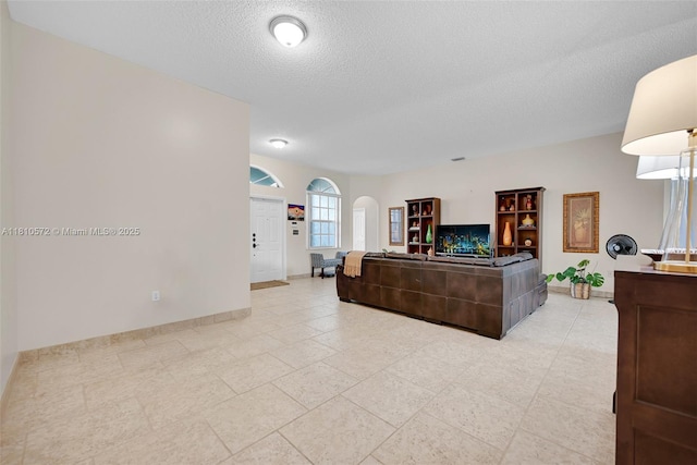2775 Dunwoodie Pl, Homestead, FL 33035 - living room with a textured ceiling, arched walkways, and baseboards