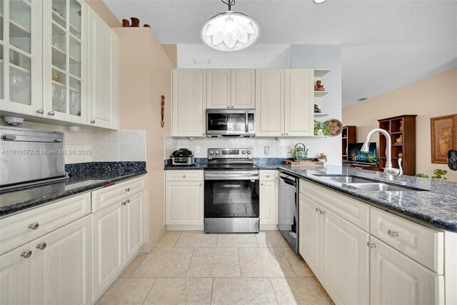 2775 Dunwoodie Pl, Homestead, FL 33035 - kitchen with stainless steel appliances, a sink, open shelves, decorative backsplash, and a textured ceiling