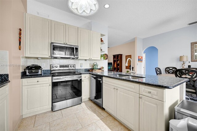 2775 Dunwoodie Pl, Homestead, FL 33035 - kitchen featuring appliances with stainless steel finishes, a sink, a peninsula, arched walkways, and tasteful backsplash