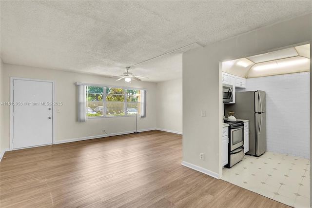 1551 SW 135th Ter Unit 112G, Pembroke Pines, FL 33027 - kitchen featuring stainless steel appliances, white cabinets, light wood-type flooring, a ceiling fan, and a textured ceiling