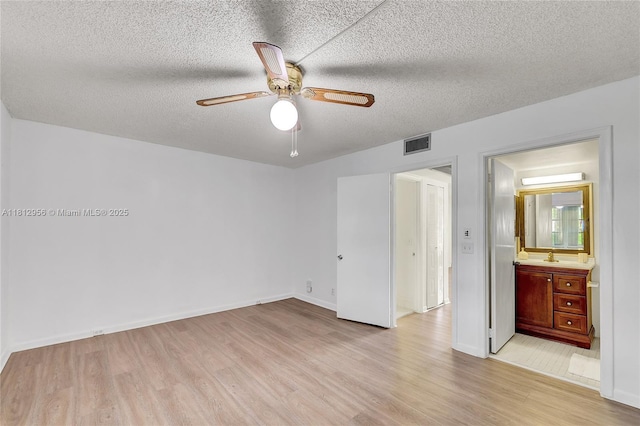 1551 SW 135th Ter Unit 112G, Pembroke Pines, FL 33027 - unfurnished bedroom featuring light wood-type flooring, a textured ceiling, a ceiling fan, and ensuite bathroom