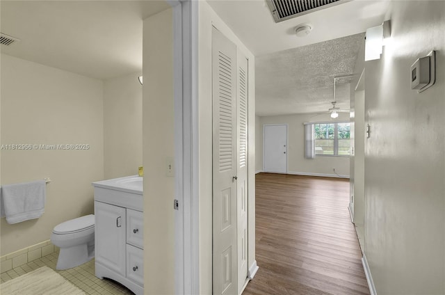 1551 SW 135th Ter Unit 112G, Pembroke Pines, FL 33027 - bathroom featuring a closet, vanity, wood finished floors, a textured ceiling, and ceiling fan