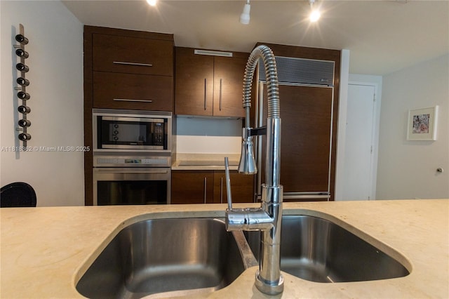 475 Brickell Ave Unit 4511, Miami, FL 33131 - kitchen featuring appliances with stainless steel finishes, dark brown cabinets, and light countertops