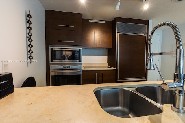 475 Brickell Ave Unit 4511, Miami, FL 33131 - kitchen with built in appliances, dark brown cabinetry, and light countertops