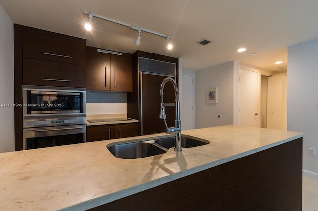 475 Brickell Ave Unit 4511, Miami, FL 33131 - kitchen with built in appliances, track lighting, dark brown cabinetry, modern cabinets, and recessed lighting