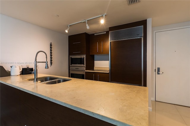 475 Brickell Ave Unit 4511, Miami, FL 33131 - kitchen with built in appliances, dark brown cabinets, light tile patterned floors, modern cabinets, and rail lighting