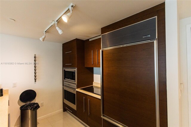475 Brickell Ave Unit 4511, Miami, FL 33131 - kitchen with built in appliances, dark brown cabinetry, light tile patterned floors, rail lighting, and light countertops