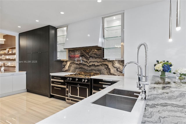 17901 Collins Ave Unit 1903, Sunny Isles Beach, FL 33160 - kitchen featuring dark cabinets, a sink, backsplash, recessed lighting, and glass insert cabinets