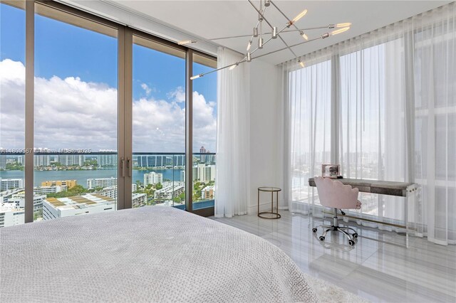17901 Collins Ave Unit 1903, Sunny Isles Beach, FL 33160 - bedroom featuring a water view, multiple windows, a wall of windows, and a chandelier