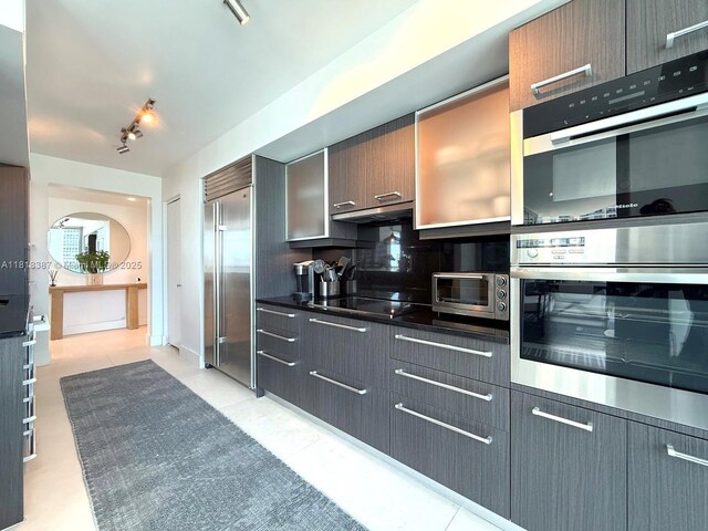 1331 Brickell Bay Dr Unit 2002, Miami, FL 33131 - kitchen with stainless steel appliances, dark countertops, and decorative backsplash