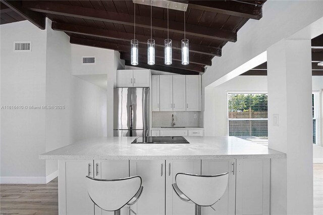 1025 SW 22nd Ter, Fort Lauderdale, FL 33312 - kitchen featuring stainless steel refrigerator, black electric cooktop, light wood-type flooring, wooden ceiling, and white cabinetry